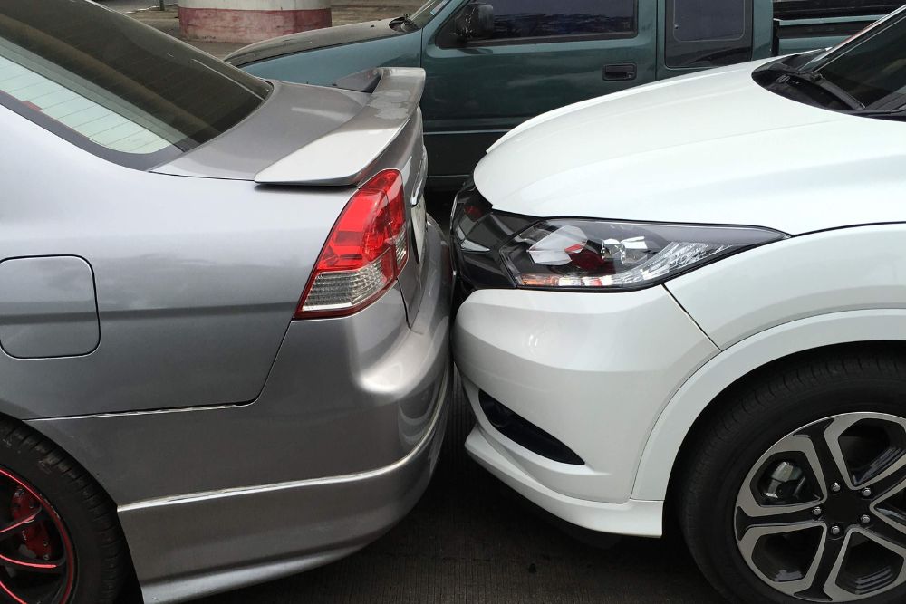 Honda & Acura certified collision repair in Harlingen, TX by Premium Collision. Close-up of a minor rear-end accident between SUV and sedan.